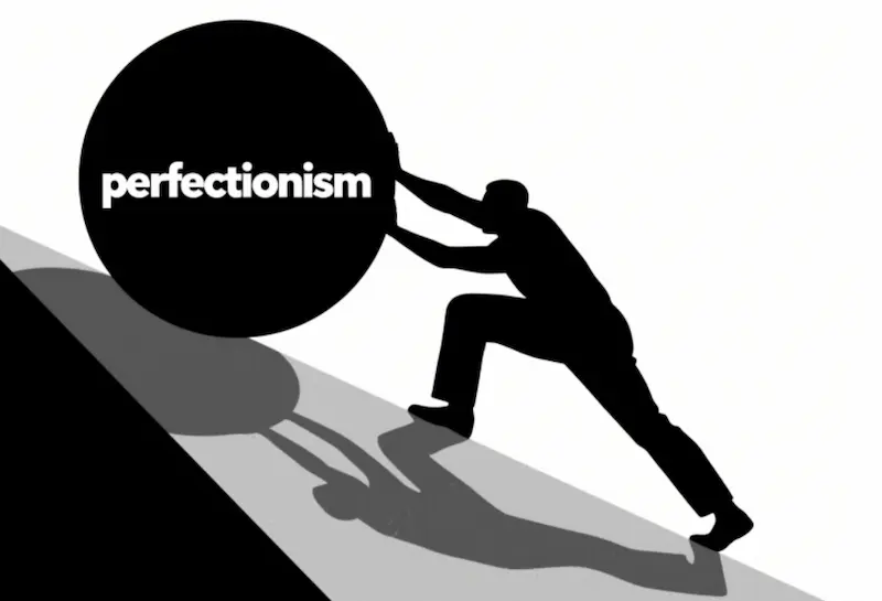 Silhouette of person pushing large 'perfectionism' ball uphill in black and white minimalist style